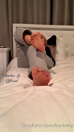 亚洲女性在看电视时展示她美丽的玉足