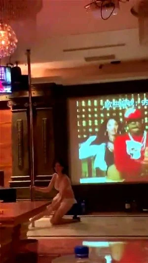和几位老友在KTV聚会，欣赏模特表演脱衣钢管舞。一位穿着背心、长相神似思聪的幸运儿，被赤裸的模特性感挑逗。
