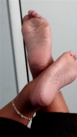 丰满黑肤女性手持大号黑阴茎自慰，展示她肉感多纹的脚底