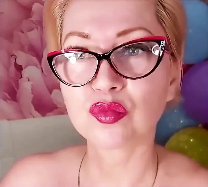 一个成熟的婊子在彩色气球的背景上假阳具